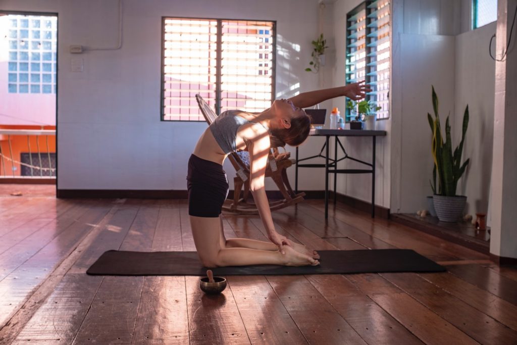 kvinna i svarta shorts och vit linne gör yoga